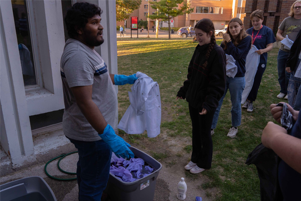 Student lining up to dye their lab coats purple